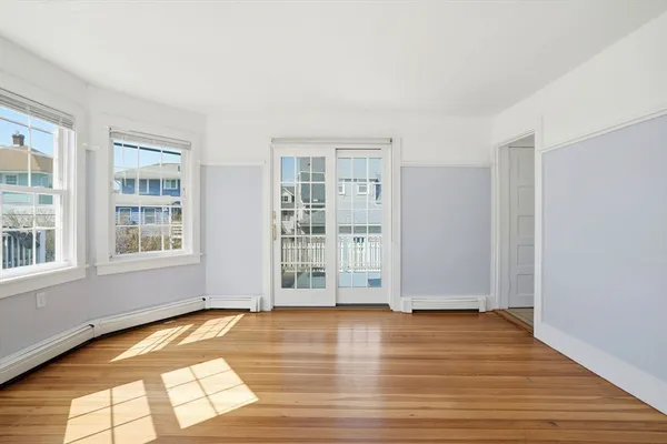 an empty room with wooden floor and windows