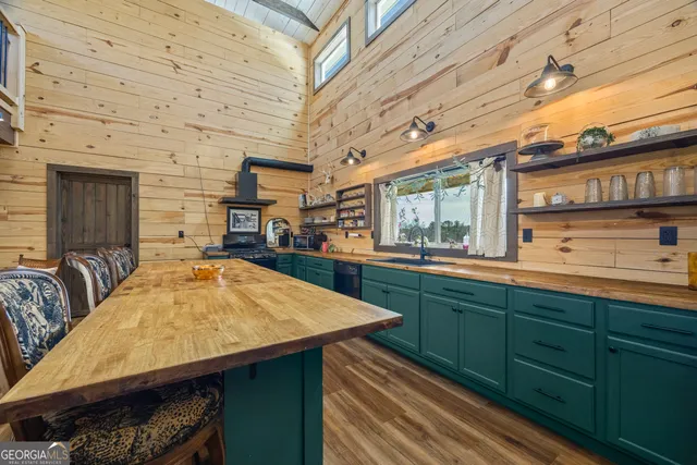 a kitchen with stainless steel appliances granite countertop lots of counter top space and wooden floor