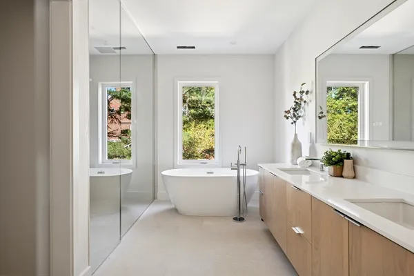 a bathroom with a granite countertop tub sink and mirror