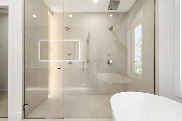 a bathroom with a shower a sink and a mirror