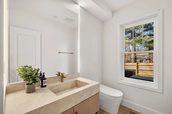 a bathroom with a sink toilet and a window