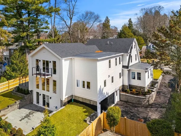 a aerial view of a house with a large tree and wooden fence