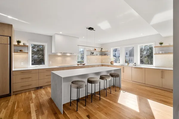 a kitchen with stainless steel appliances granite countertop a stove a sink dishwasher and a refrigerator with wooden floor