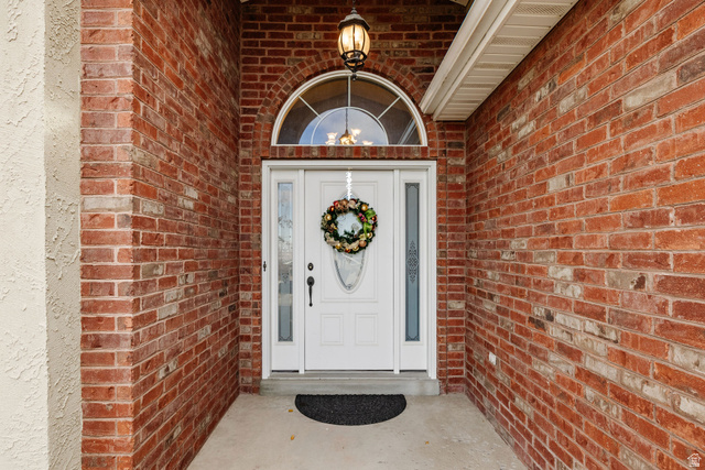 240 Bugle Way Providence, UT 84332 - Photo 2 of 15 Entryway featuring a white door with sidelights, an arched transom window, and a decorative overhead light fixture
