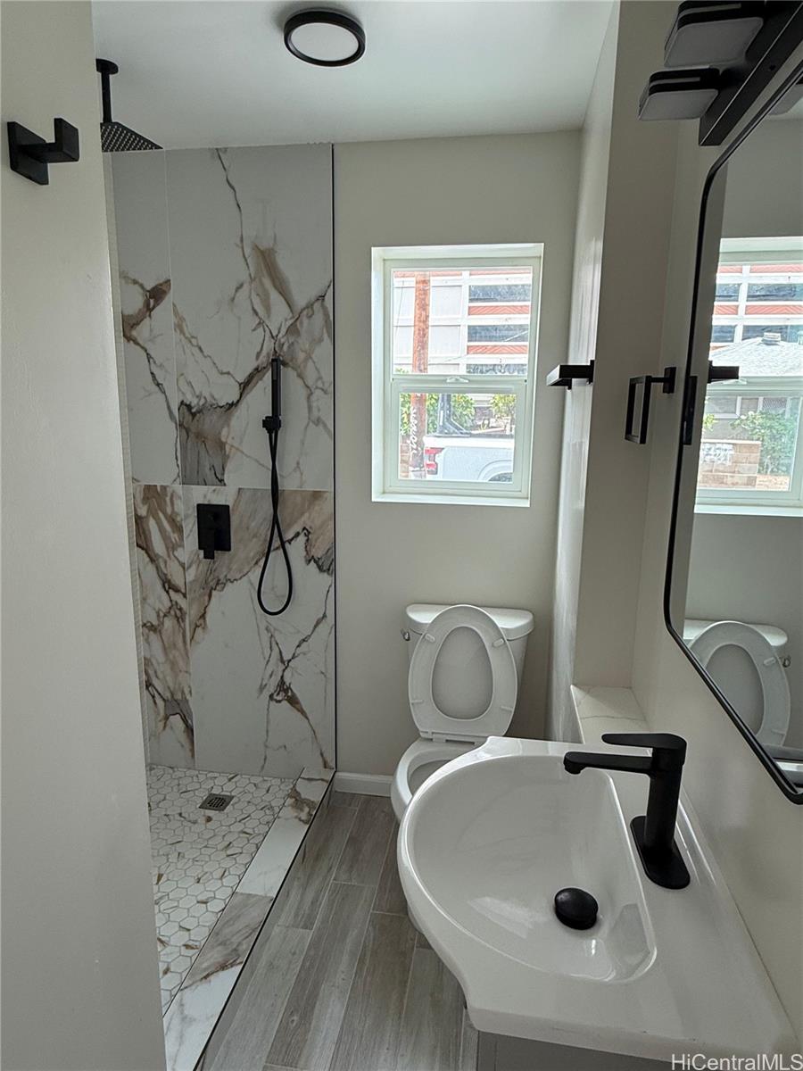 2711 Waiaka Road Honolulu, HI 96826 - Photo 13 of 19 a bathroom with a sink and mirror with bathtub