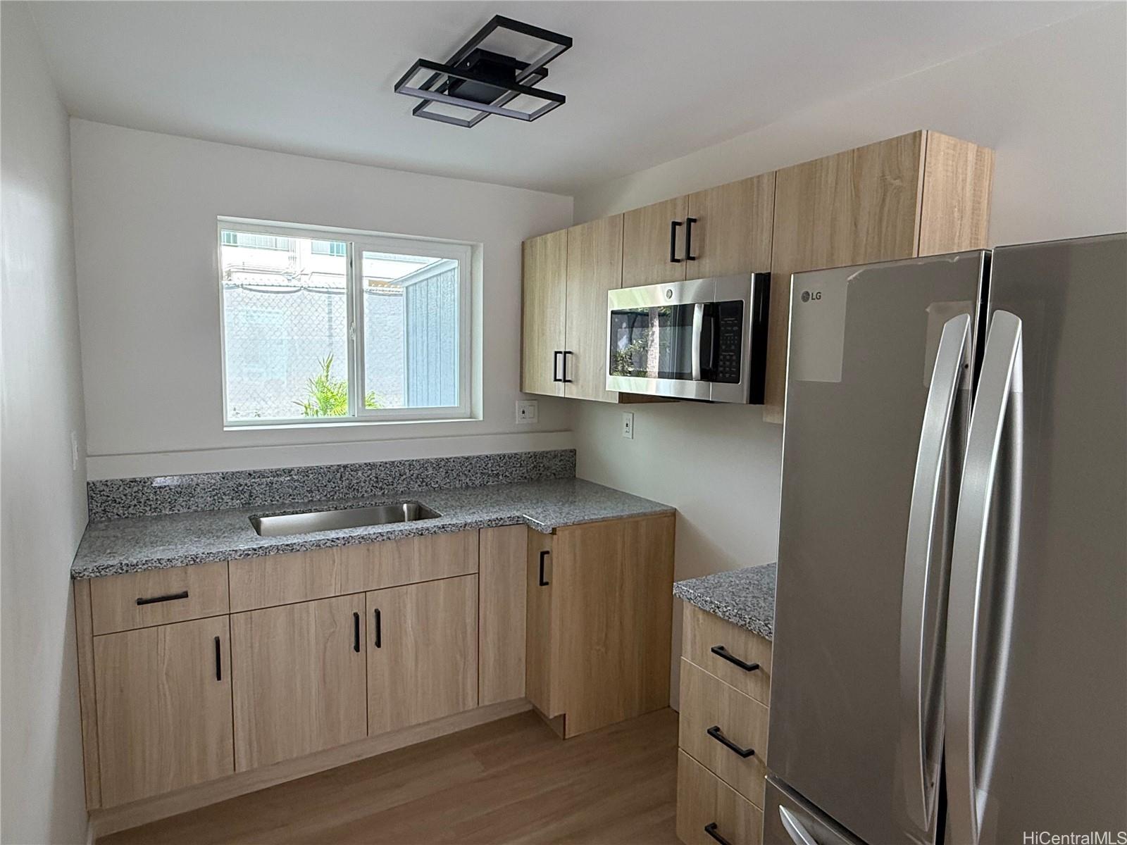 2711 Waiaka Road Honolulu, HI 96826 - Photo 15 of 19 a kitchen with stainless steel appliances granite countertop a refrigerator a stove a sink and a microwave