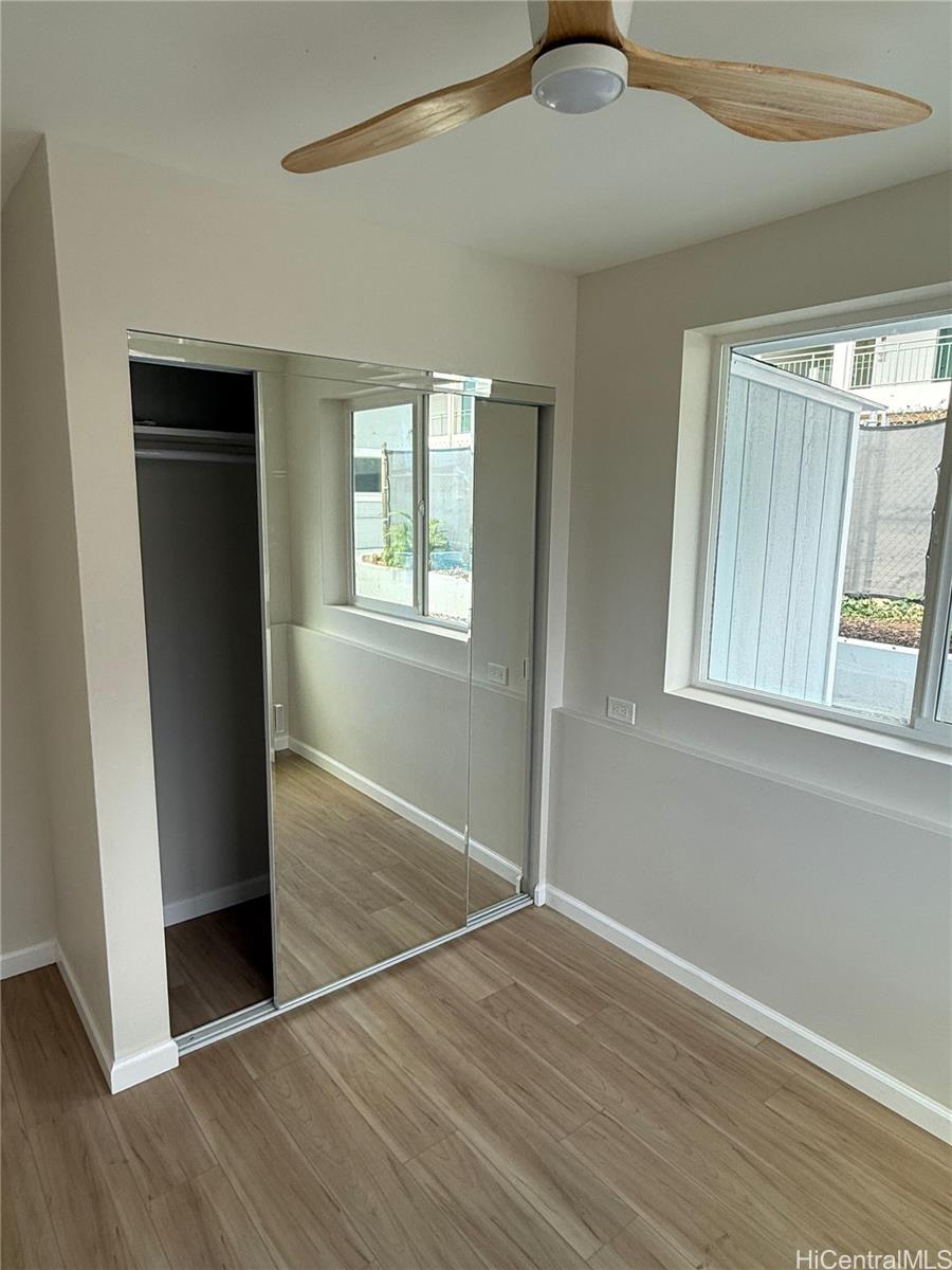 2711 Waiaka Road Honolulu, HI 96826 - Photo 17 of 19 an empty room with wooden floor cabinet and windows