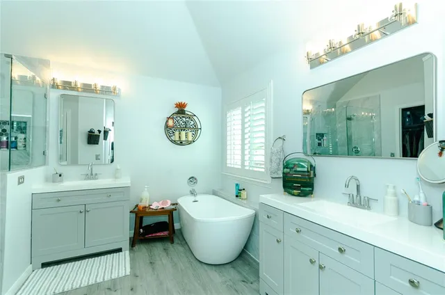 a bathroom with a tub sink and mirror