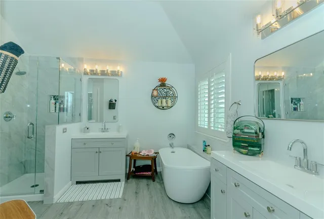 a spacious bathroom with a double vanity sink mirror and bathtub