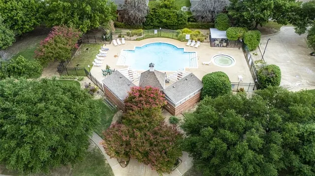 a view of a white house with a yard and potted plants