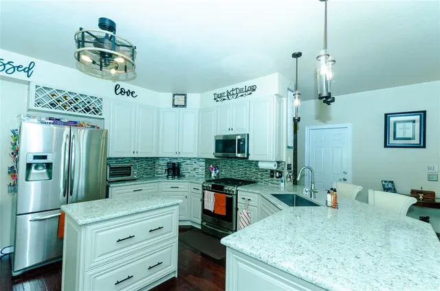 a kitchen with kitchen island a counter top space appliances and cabinets