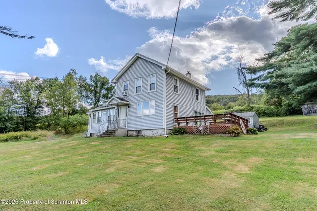 a view of a house with a yard and sitting area