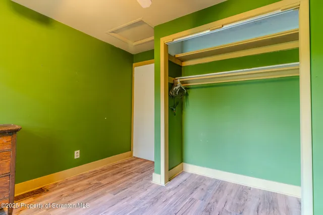 a bedroom with a bed a dresser and a chandelier