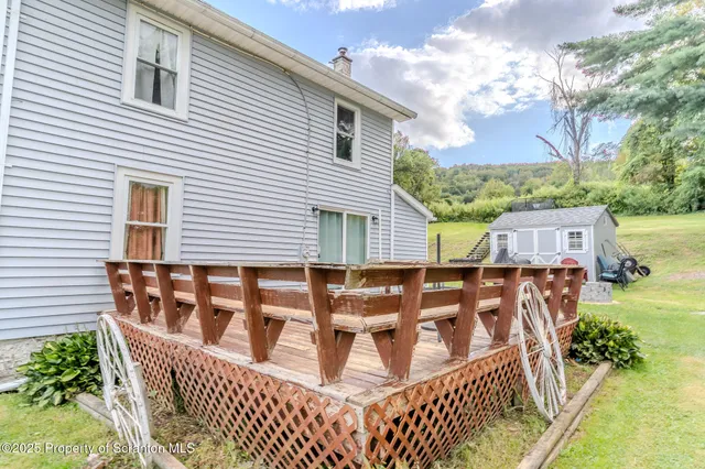 a view of a house with backyard and deck