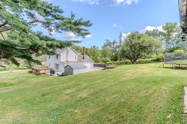 a view of a house with a big yard and large trees