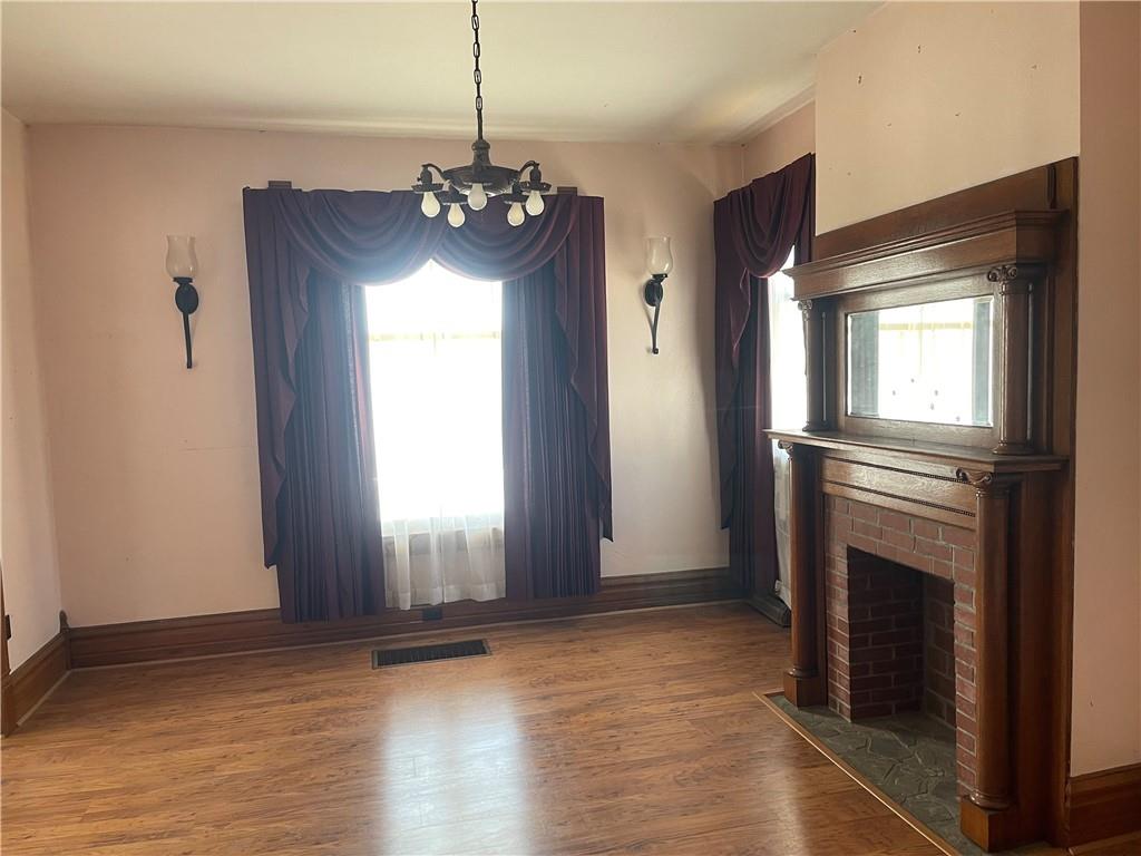 943 Newell Road Fayette City, PA 15438 - Photo 5 of 27 a view of an empty room with wooden floor fireplace and a window