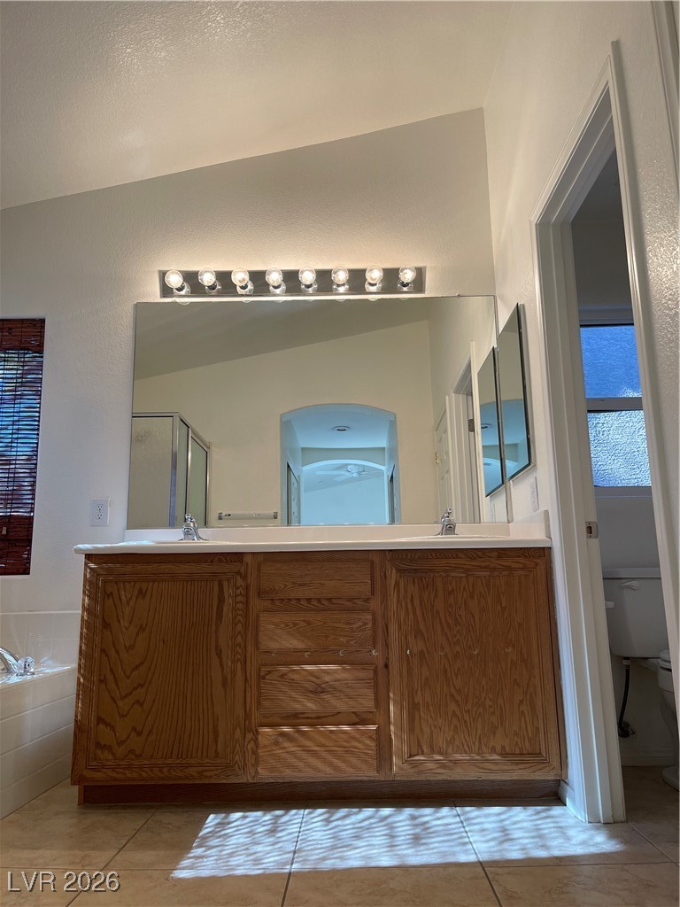 9975 Willowbrook Pond Road Las Vegas, NV 89148 - Photo 12 of 18 Bathroom with a garden tub, double vanity, light tile patterned floors, and a stall shower