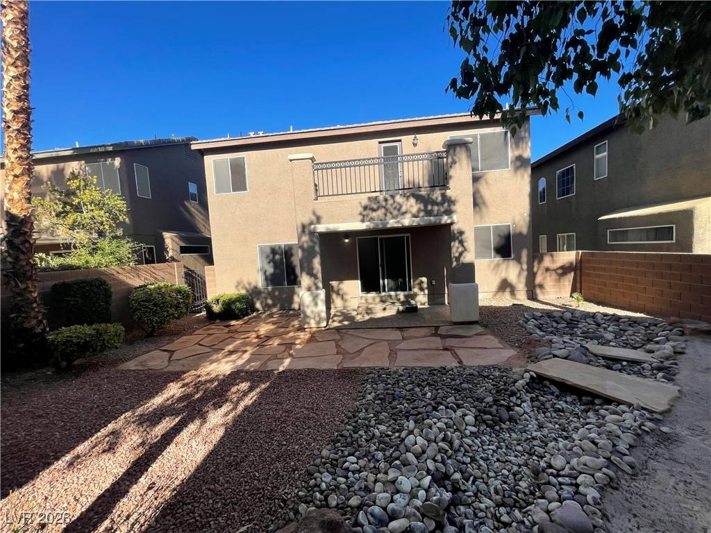 9975 Willowbrook Pond Road Las Vegas, NV 89148 - Photo 18 of 18 Rear view of house with stucco siding, a patio, and a balcony