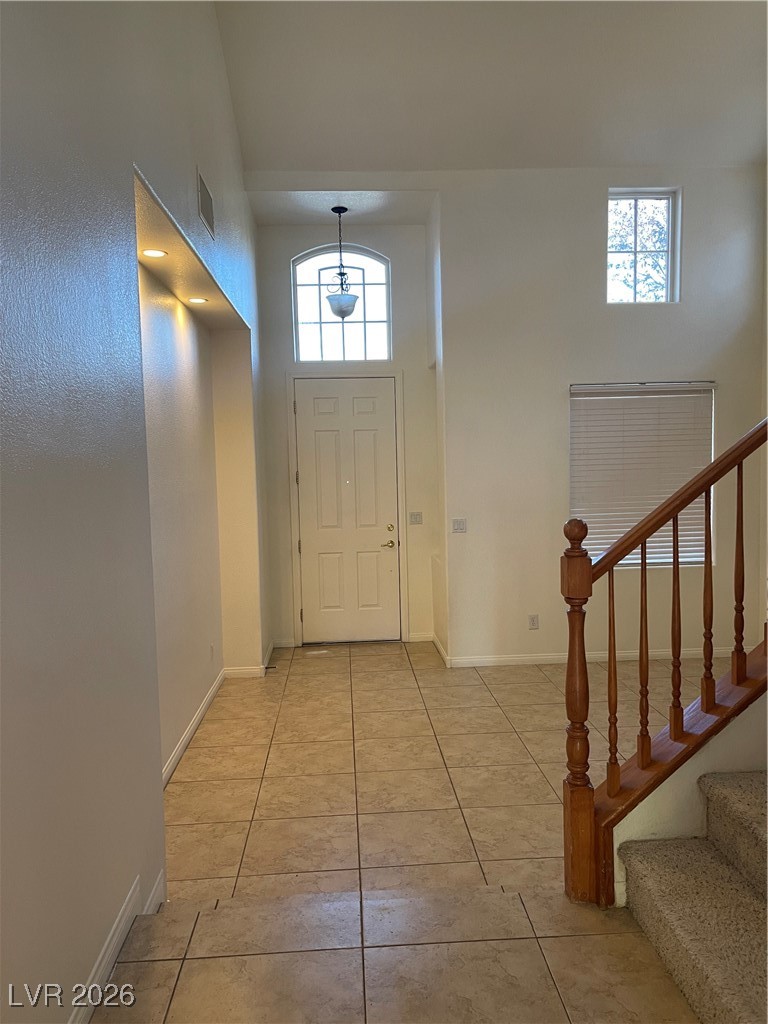 9975 Willowbrook Pond Road Las Vegas, NV 89148 - Photo 6 of 18 Foyer entrance with stairway, light tile patterned floors, and a towering ceiling