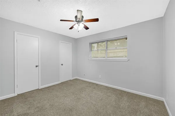 a bedroom with a bed a potted plant on dresser and a chandelier