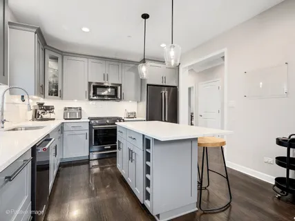 a kitchen with a sink a counter top space stainless steel appliances and cabinets