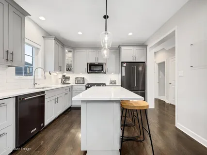 a kitchen with kitchen island a sink appliances and cabinets