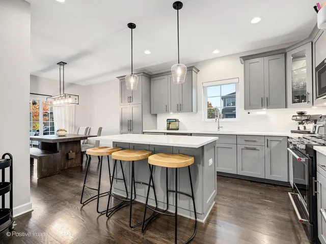 a kitchen with a table chairs sink and cabinets