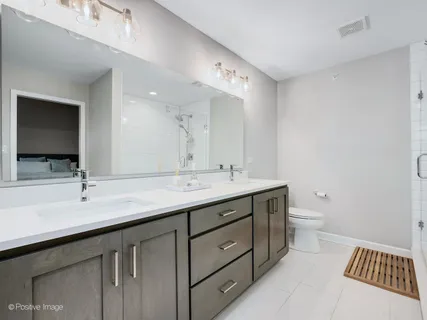 a bathroom with a double vanity sink and a toilet