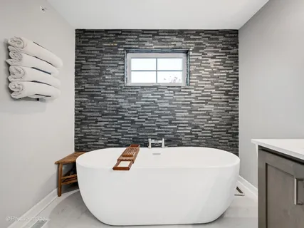 a bathroom with a sink a bathtub and mirror
