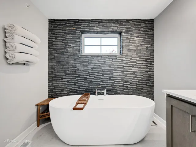 a bathroom with a sink a bathtub and mirror
