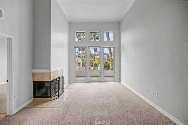 an empty room with fireplace and windows
