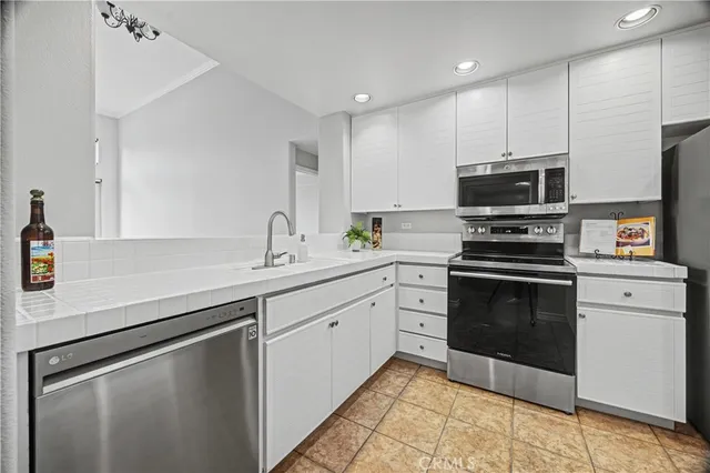 a kitchen with a sink stainless steel appliances and cabinets