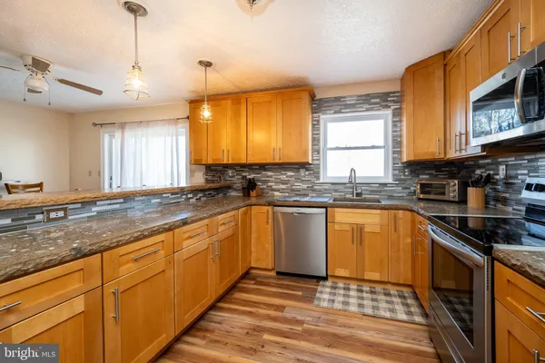 a kitchen with stainless steel appliances a refrigerator sink and microwave