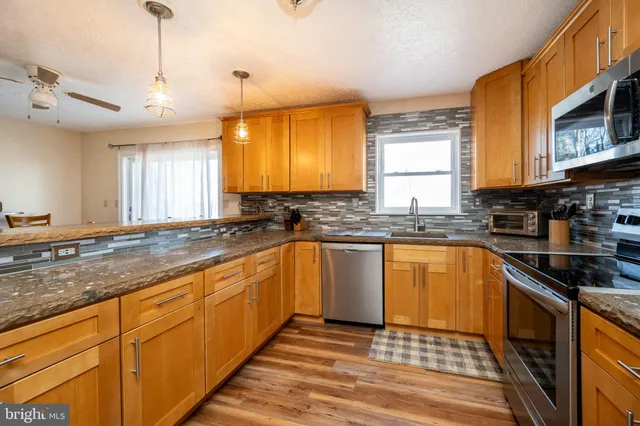 a kitchen with stainless steel appliances a refrigerator sink and microwave