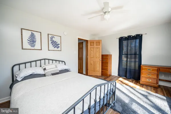 a bedroom with a bed and a flat tv screen on dresser