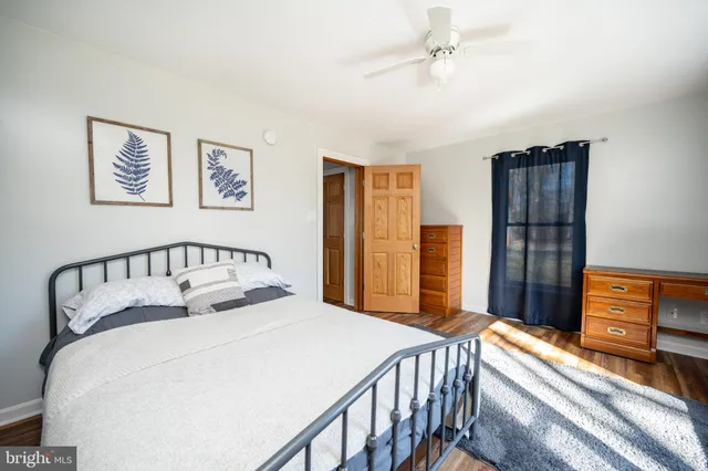 a bedroom with a bed and a flat tv screen on dresser