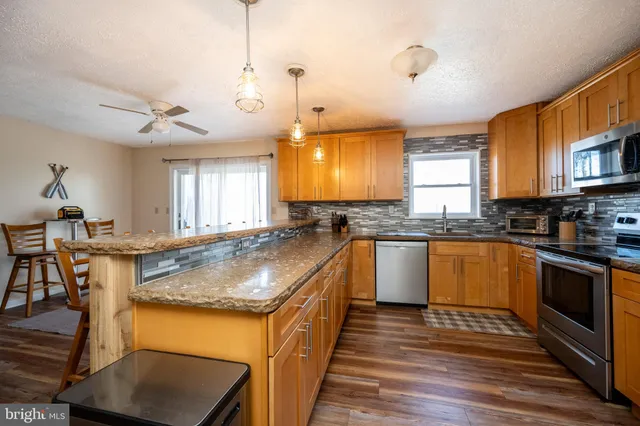 a kitchen with stainless steel appliances a stove microwave and refrigerator