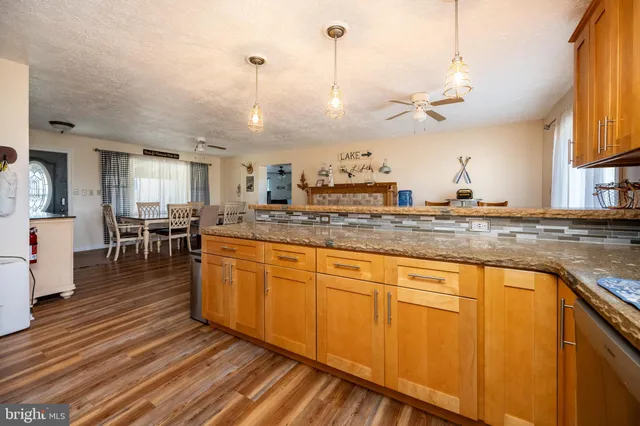 a kitchen with granite countertop a sink a counter space cabinets and a counter top space