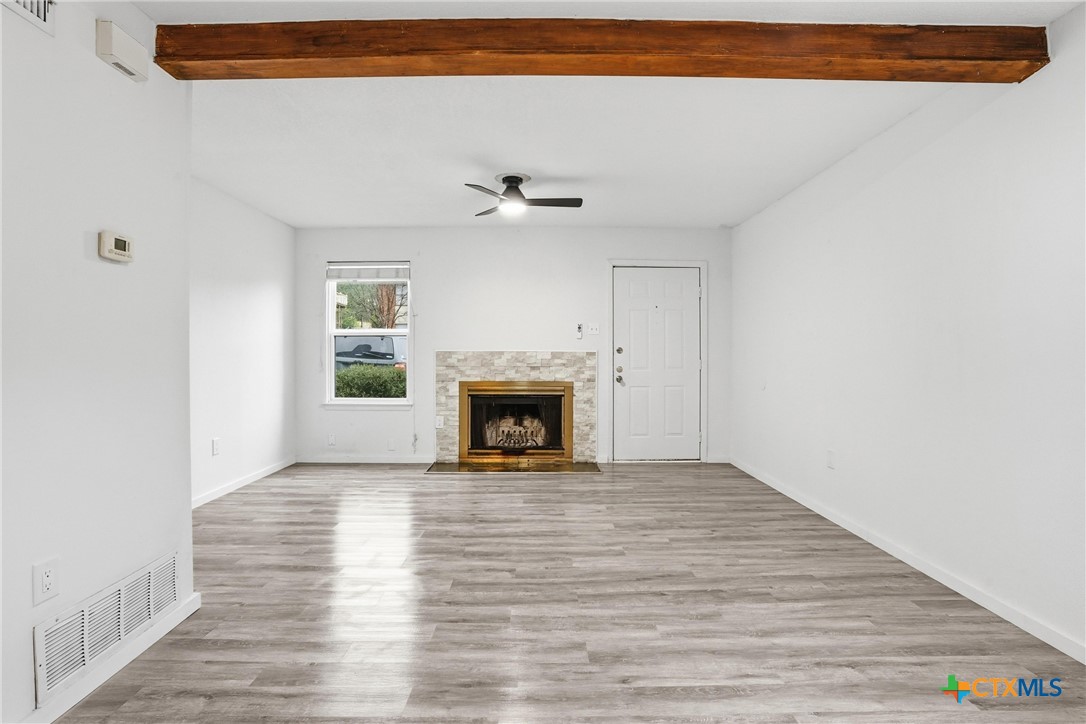 922 North 7th Street Copperas Cove, TX 76522 - Photo 7 of 26 a view of a livingroom with a fireplace a ceiling fan and wooden floor