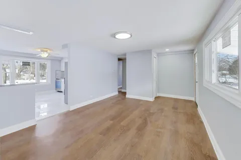 a view of empty room with wooden floor and windows