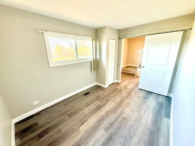 a view of a room with wooden floor and cabinet