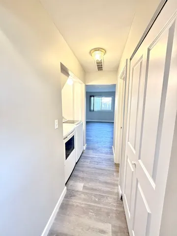 a view of a hallway with wooden floor and staircase
