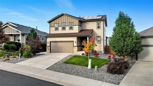 a front view of a house with a yard and potted plants