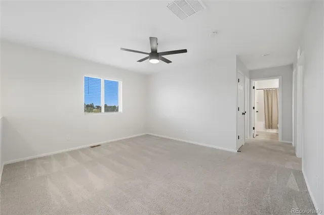 an empty room with chandelier fan