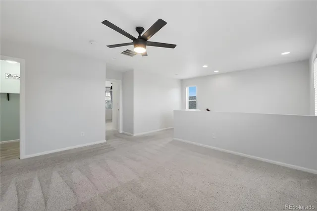 an empty room with a window and a fan