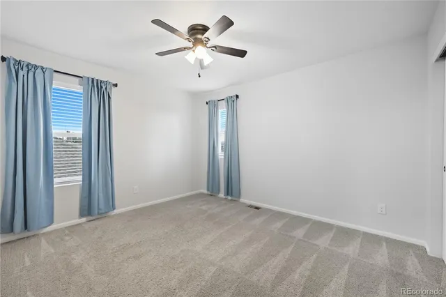 an empty room with chandelier fan