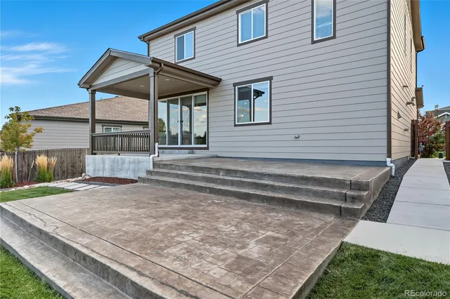 a front view of a house with a yard and potted plants
