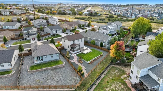an aerial view of residential houses with outdoor space and parking