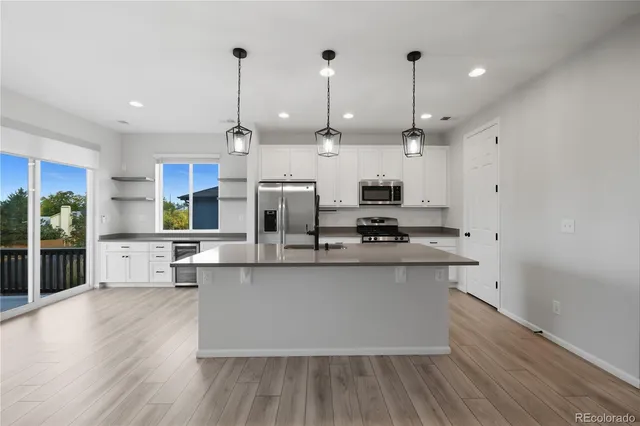 a large kitchen with stainless steel appliances kitchen island granite countertop a large counter top space a sink and cabinets