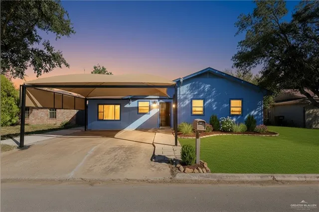 a view of a house with backyard and a tree